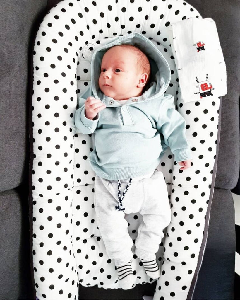 Baby in a polka dot design portable crib 