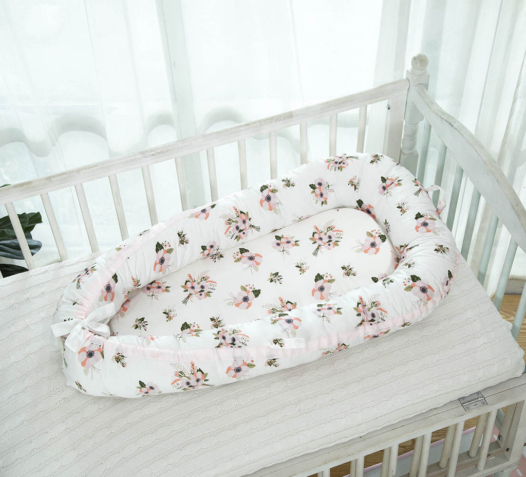 Portable baby crib with flower design in a baby cot
