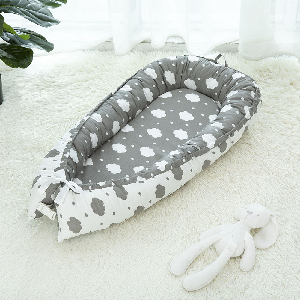 Grey portable baby crib with white clouds 